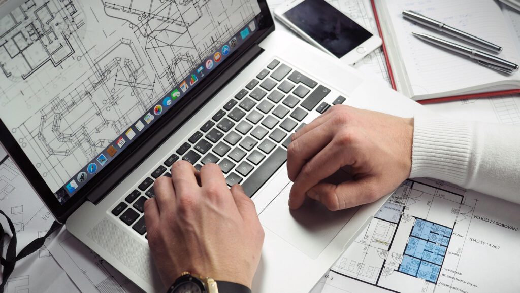 Mann sitzt am Laptop und plant Bau